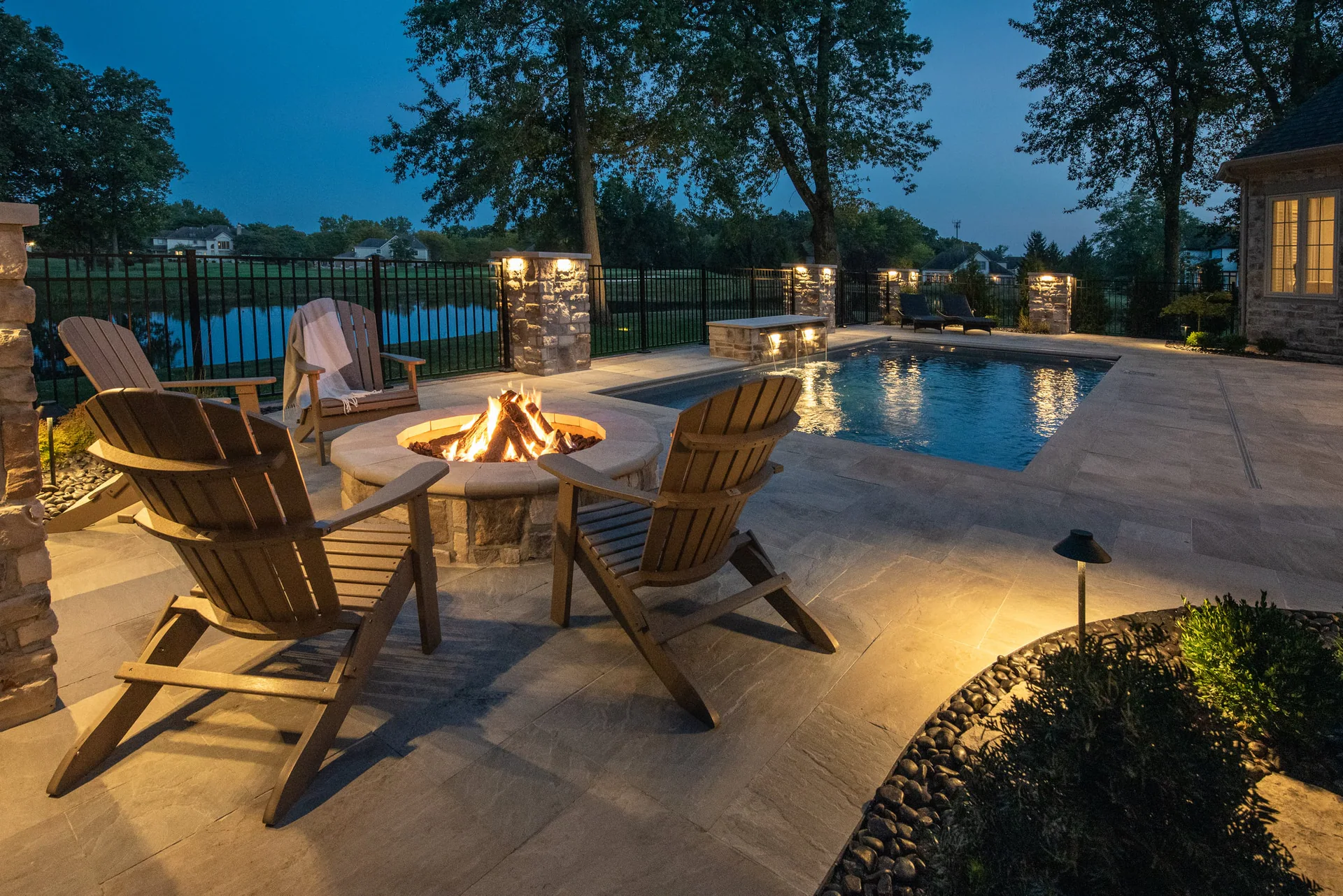 Poolside lighting and fire feature at dusk